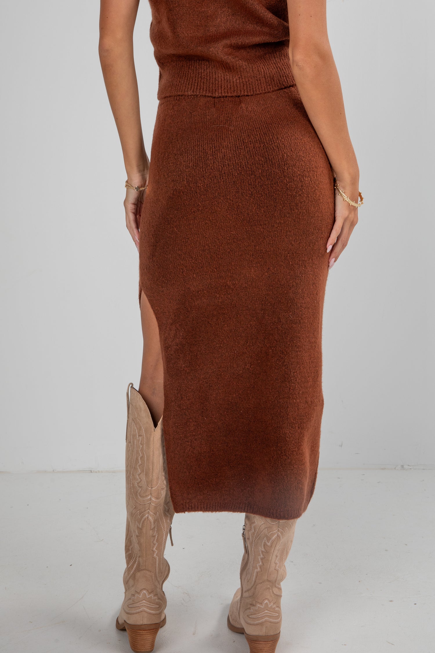 Brown knit skirt worn by a person on a white background