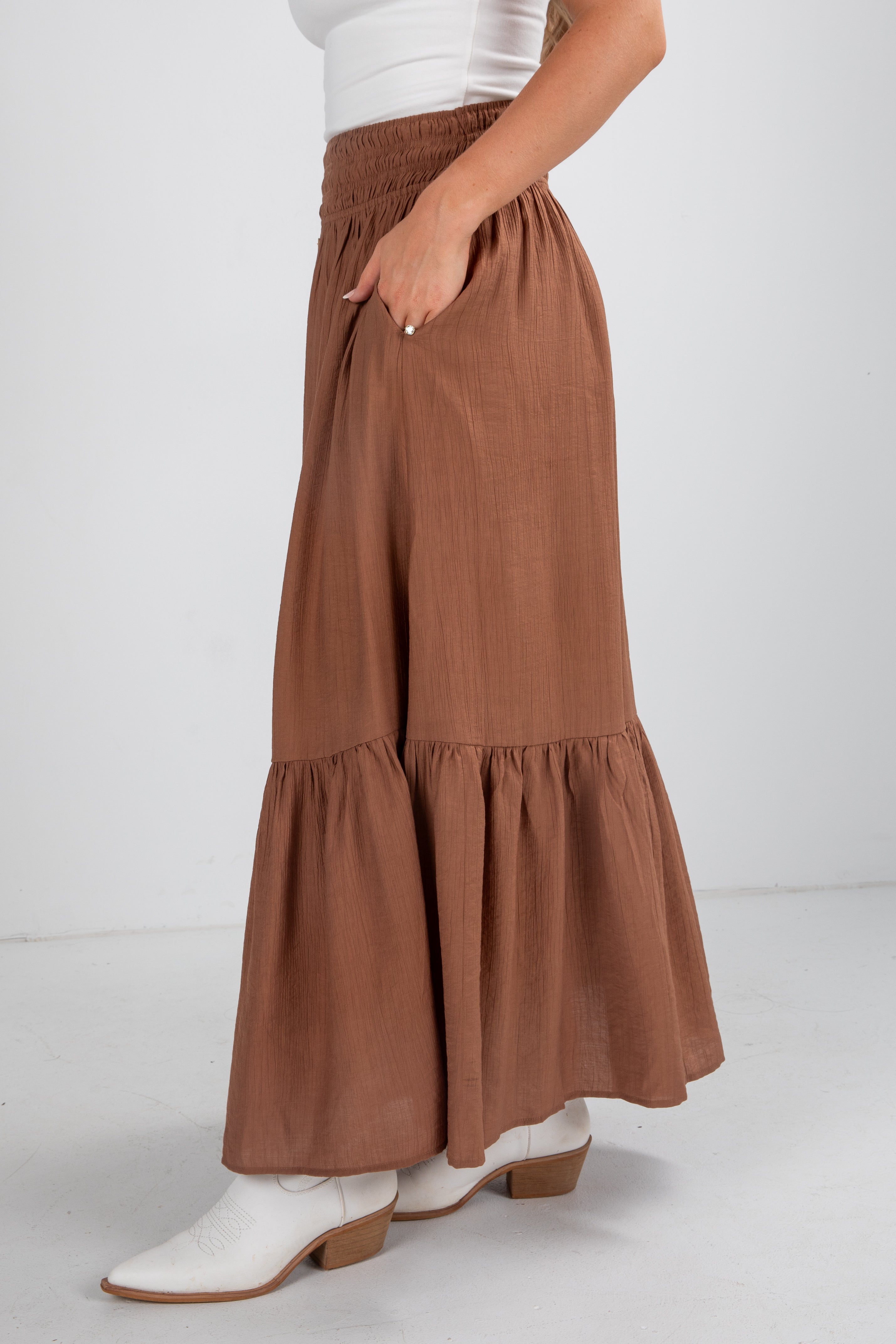 Brown tiered skirt worn by a person on a white background