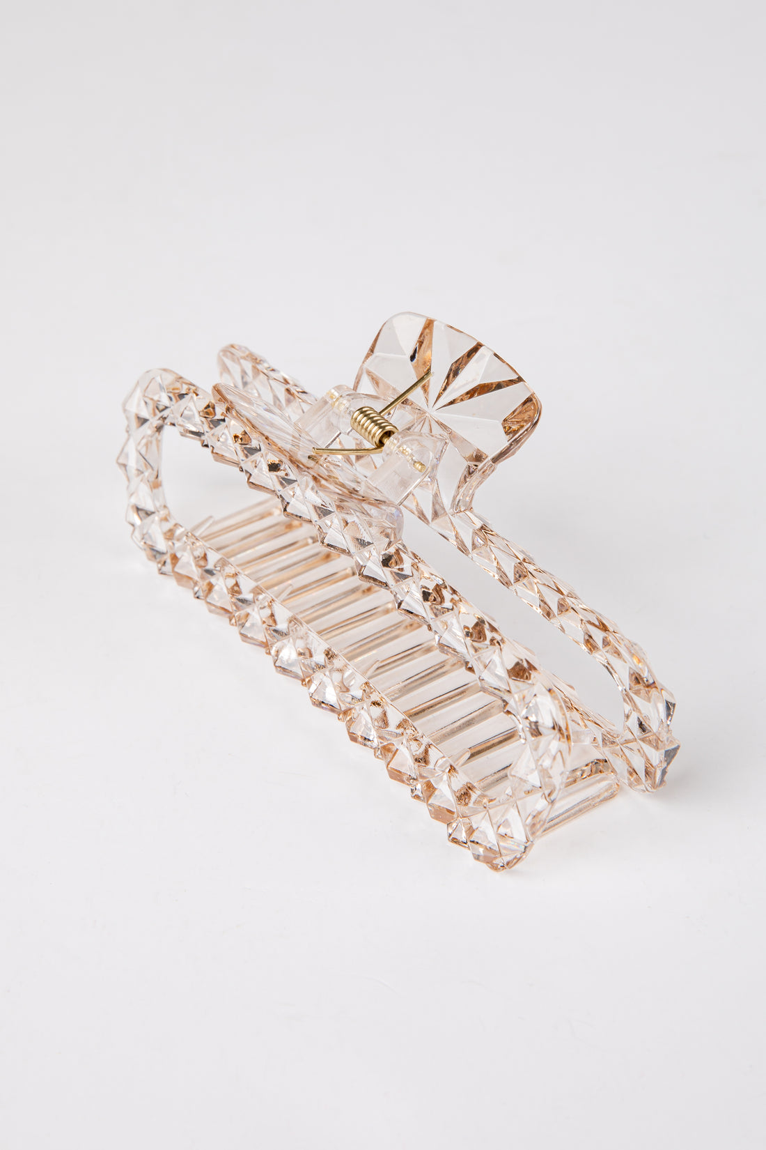 Clear hair clip with gold accents on a white background