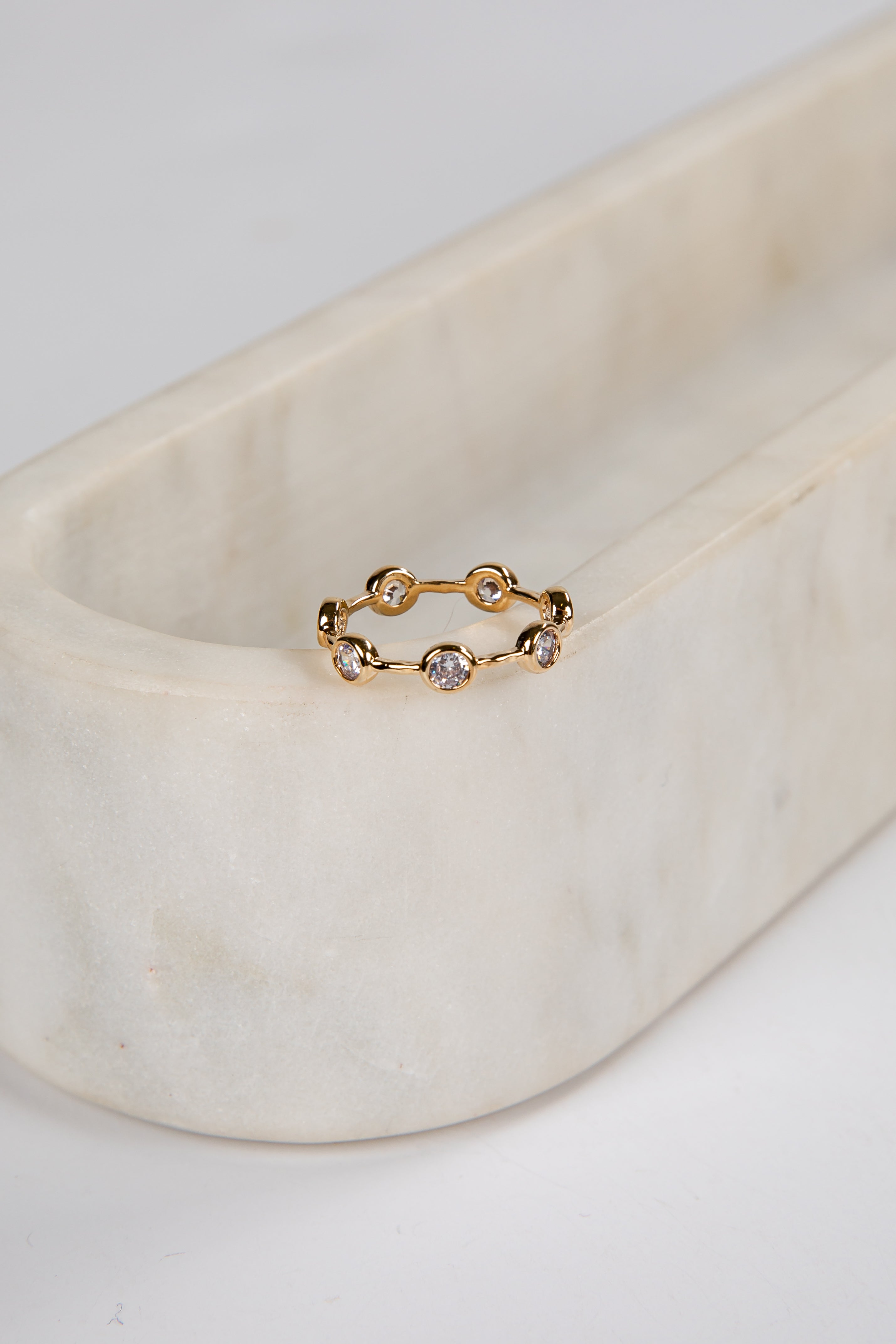 Gold ring with small diamonds on a marble surface