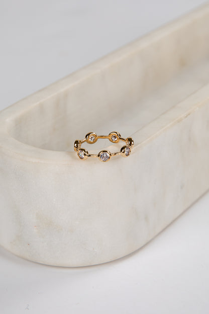 Gold ring with small diamonds on a marble surface