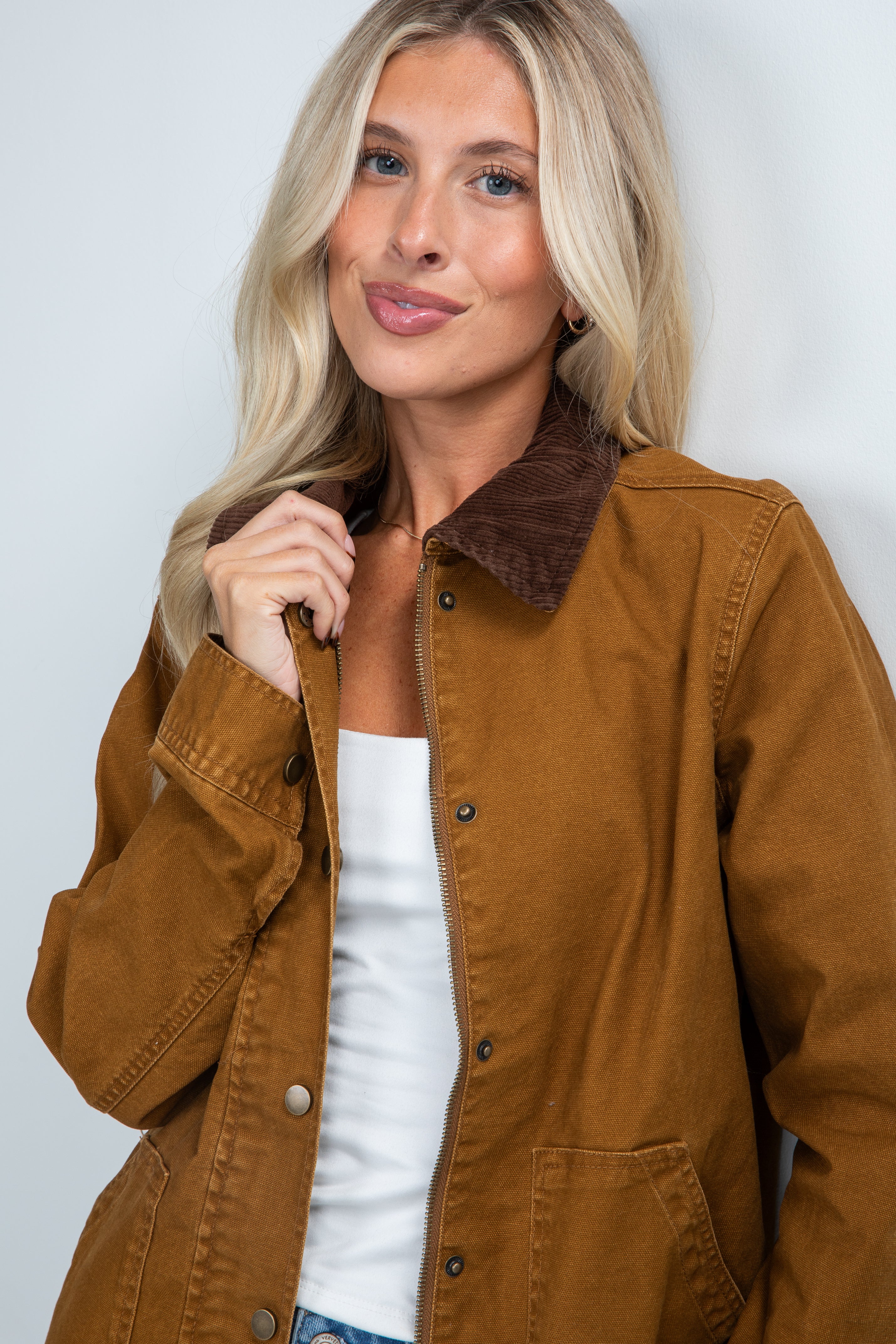 Woman wearing a brown jacket with a white background