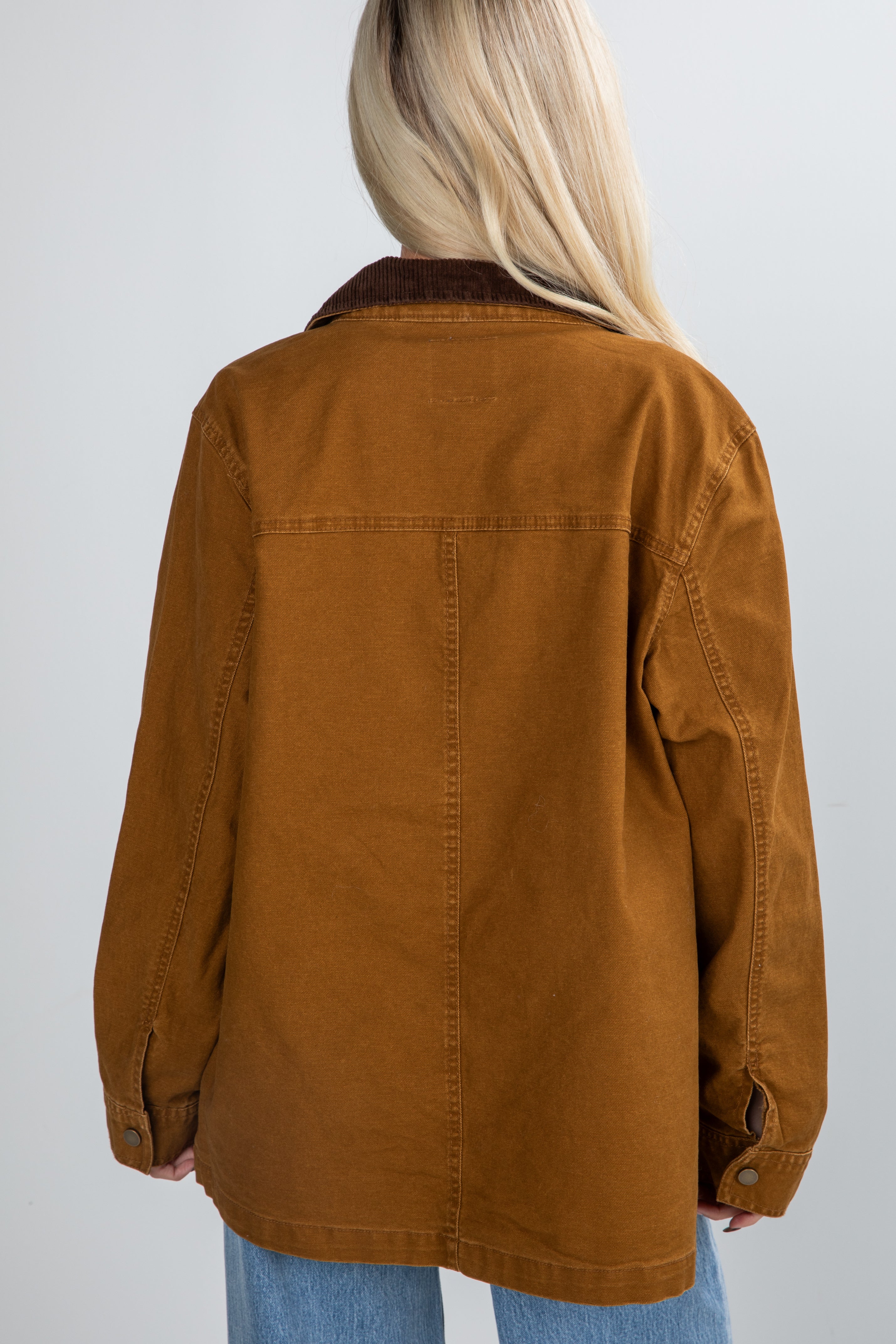Brown jacket worn by a person on a plain background