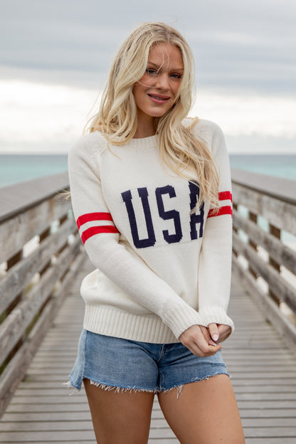 Woman wearing a white sweater with &