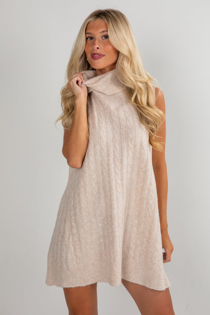 Woman wearing a beige sleeveless dress against a plain background