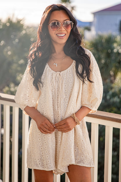Woman in a white dress standing on a balcony with a scenic background