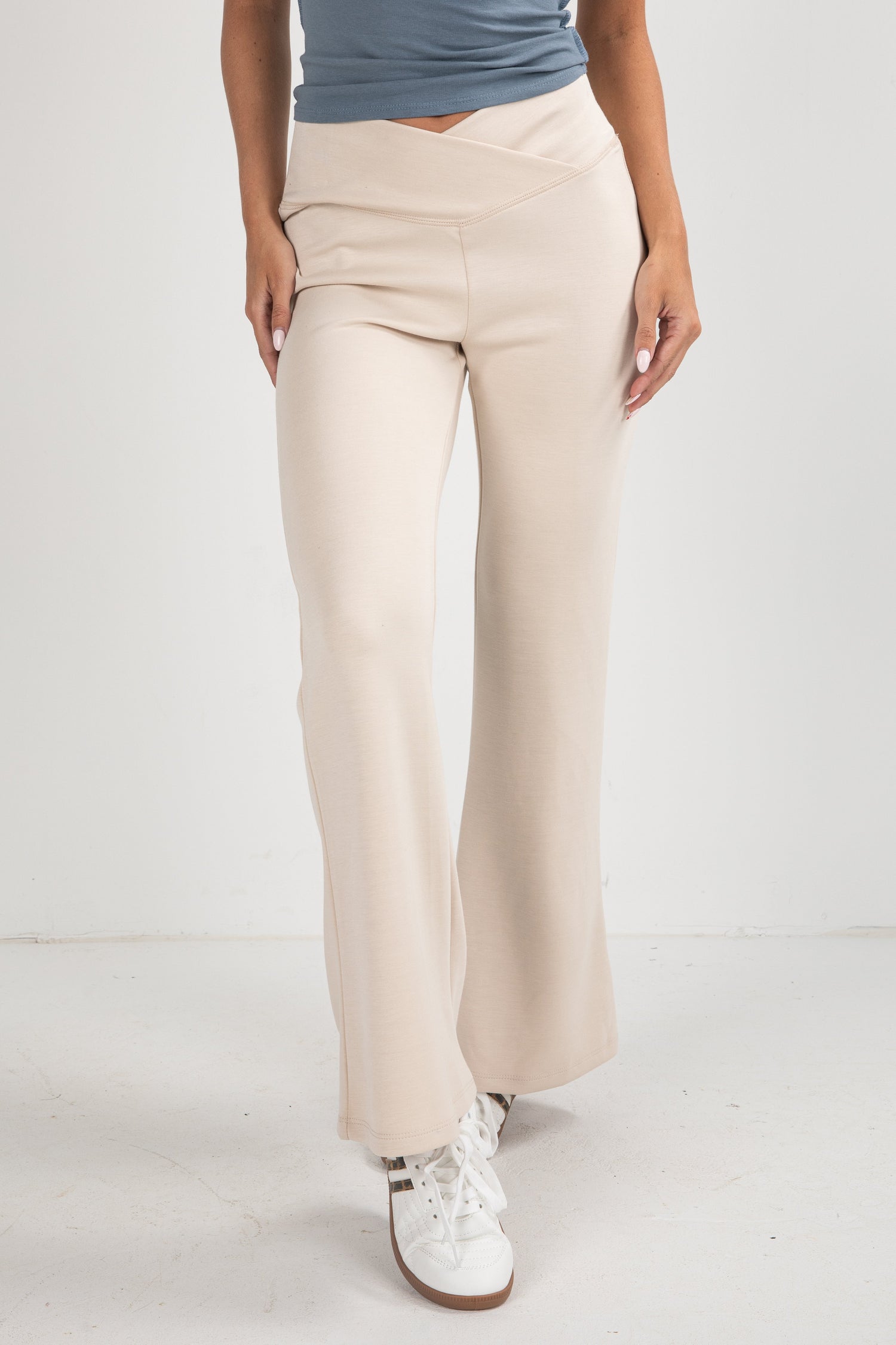 Beige pants worn by a person on a white background