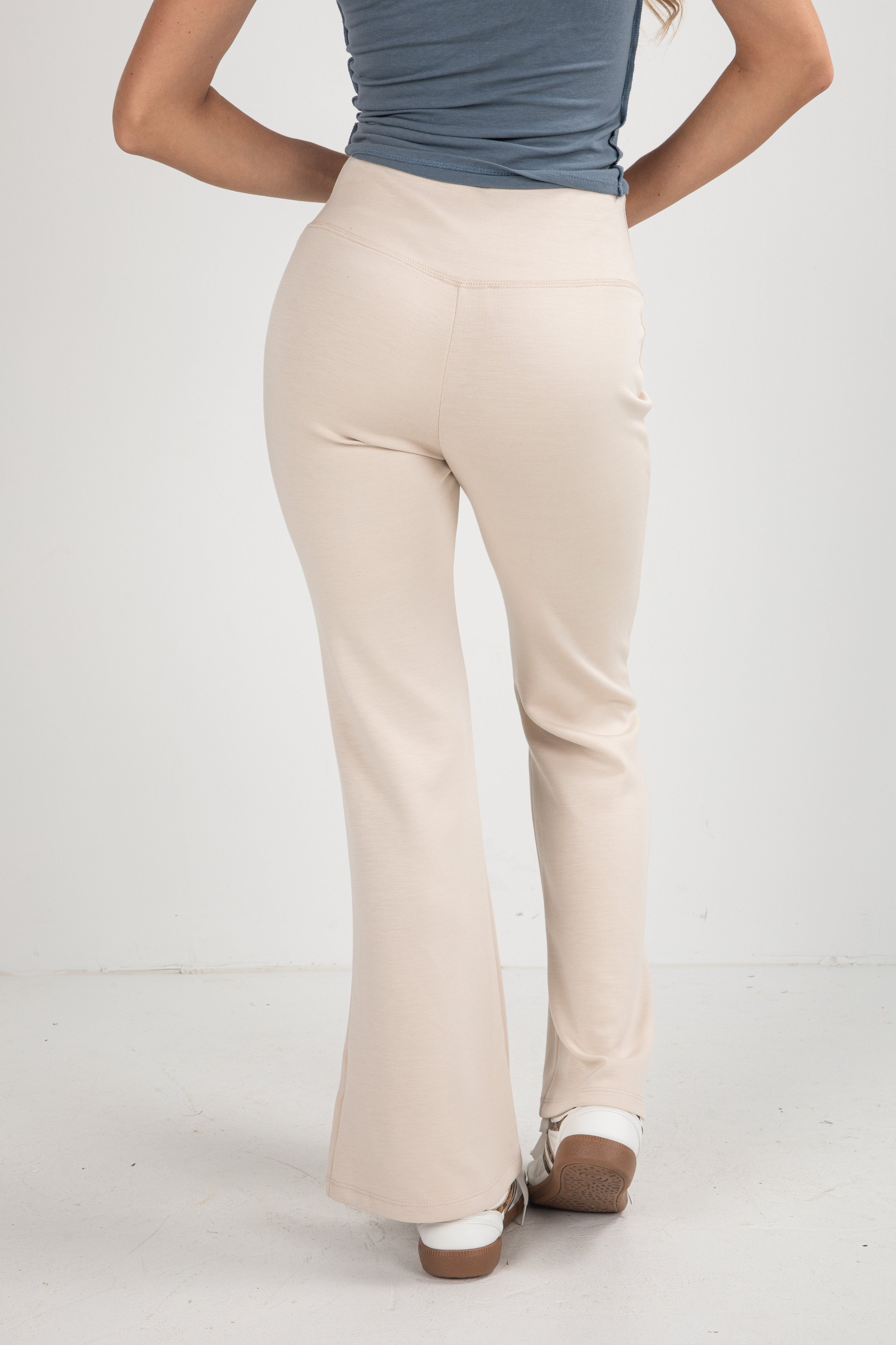 Beige pants worn by a person on a white background