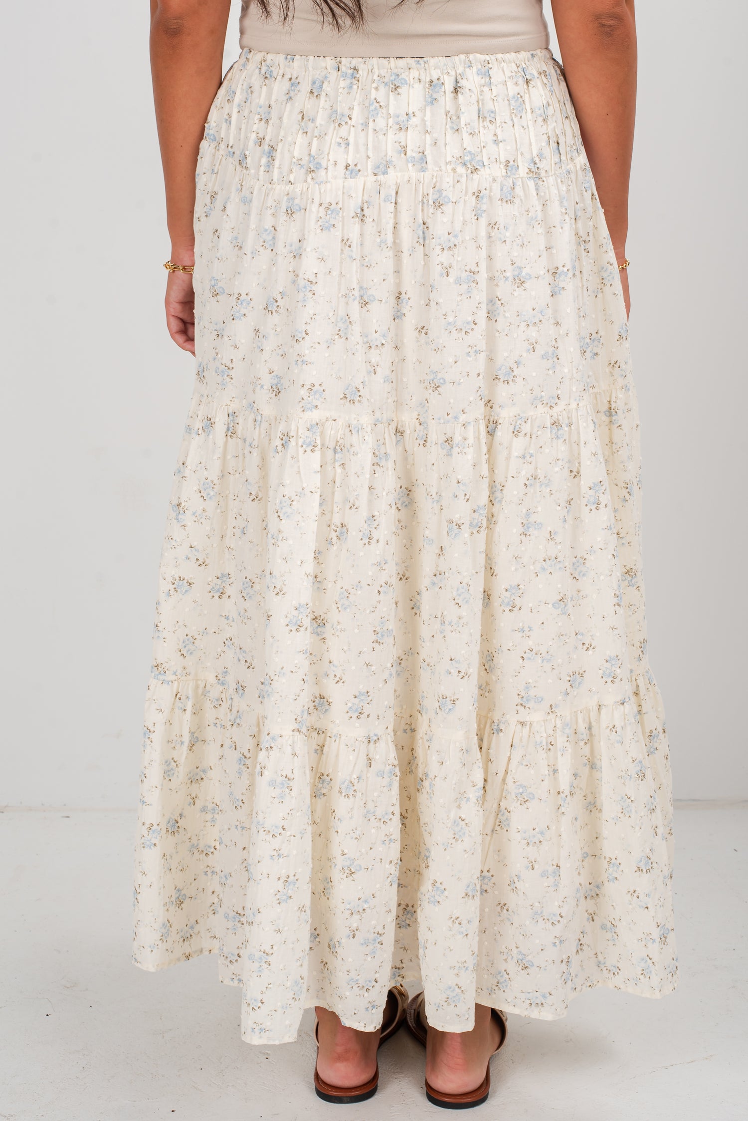 Long floral skirt worn by a person on a white background