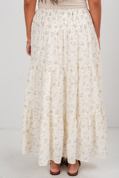 Long floral skirt worn by a person on a white background