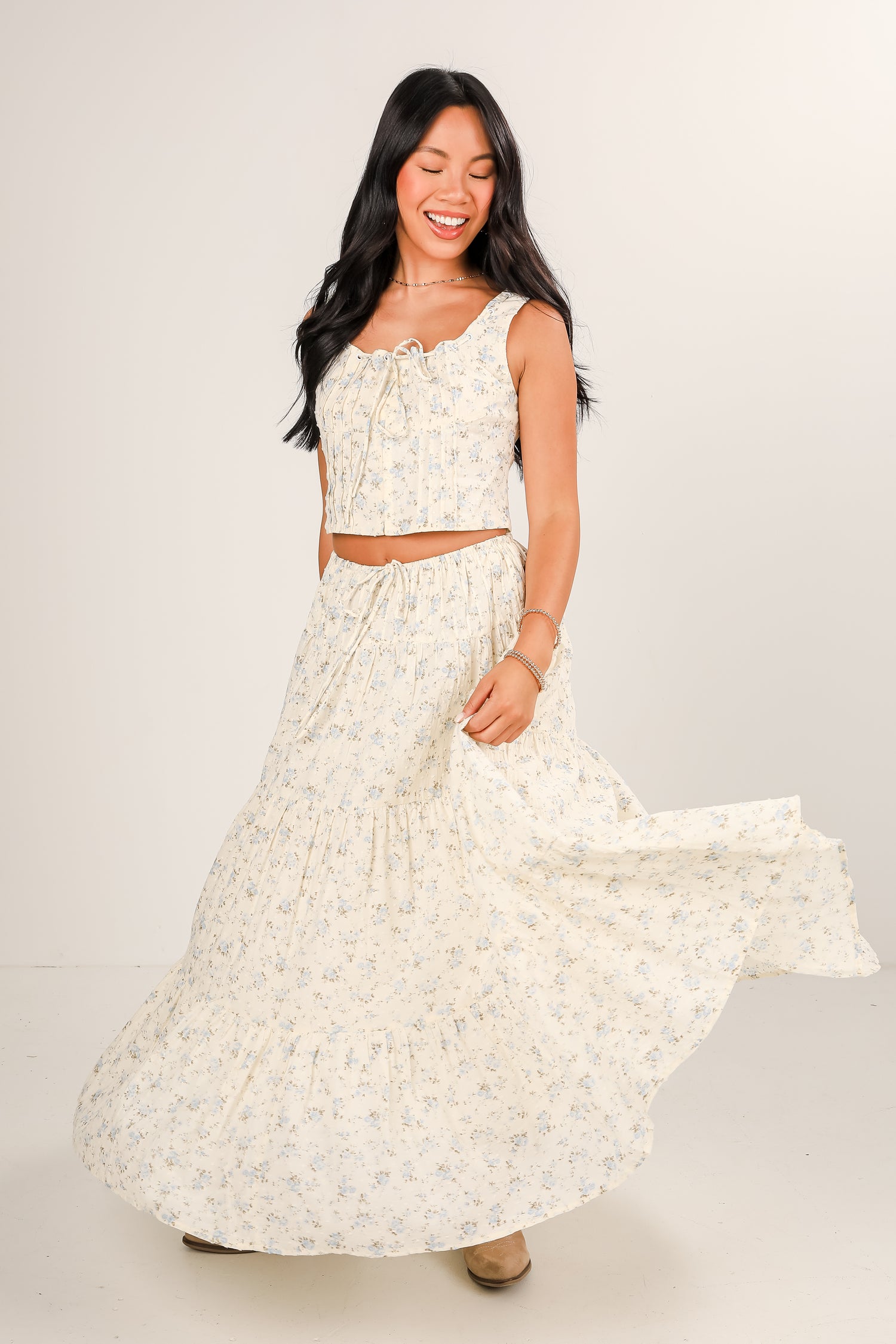 Woman wearing a white floral dress against a plain background