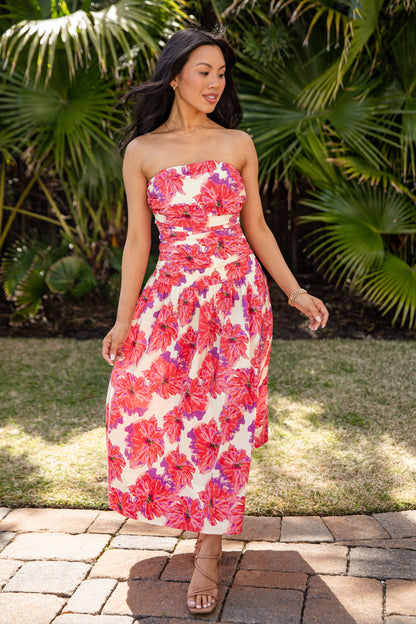 Woman wearing a strapless floral dress in a garden setting