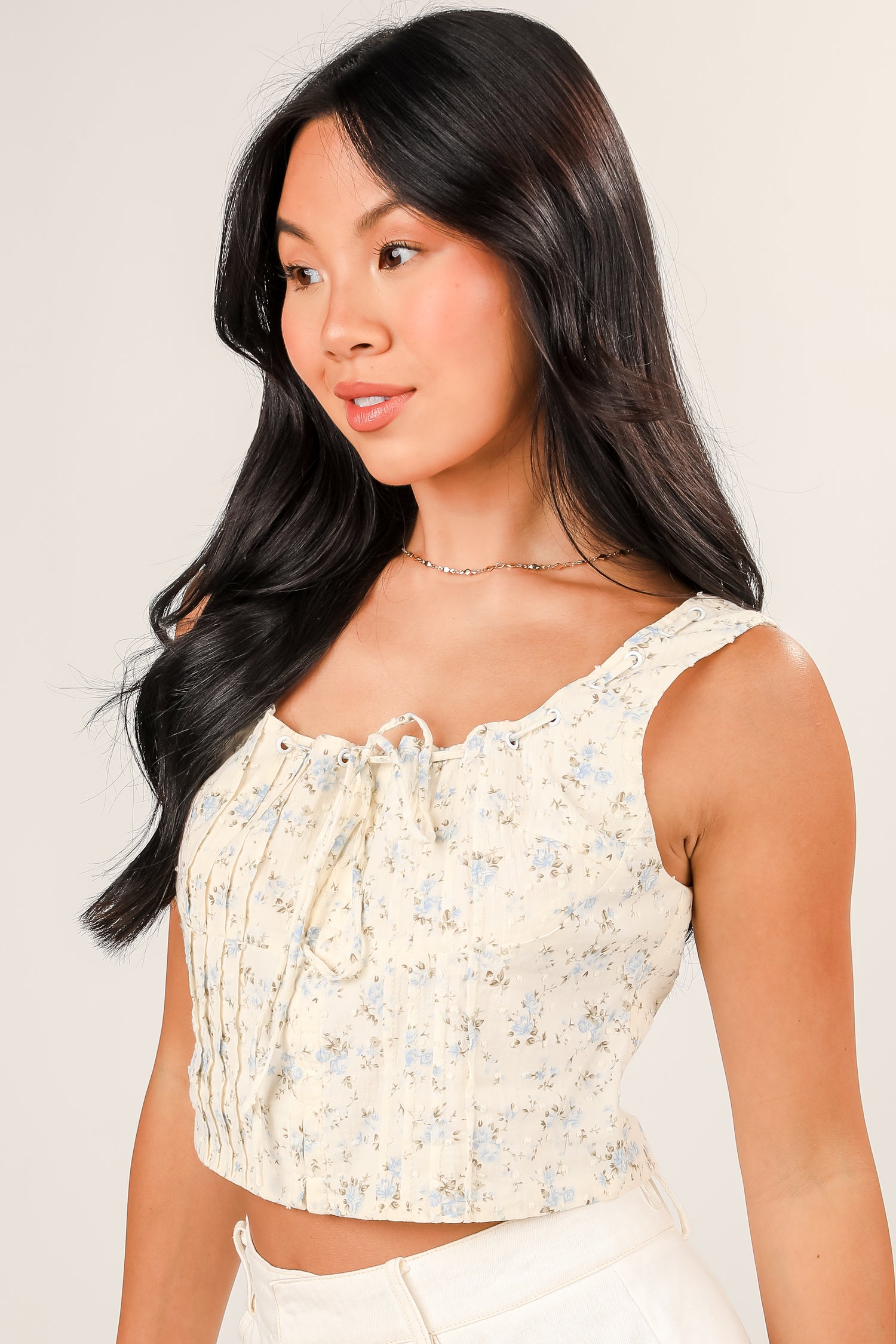 Woman wearing a floral top against a plain background