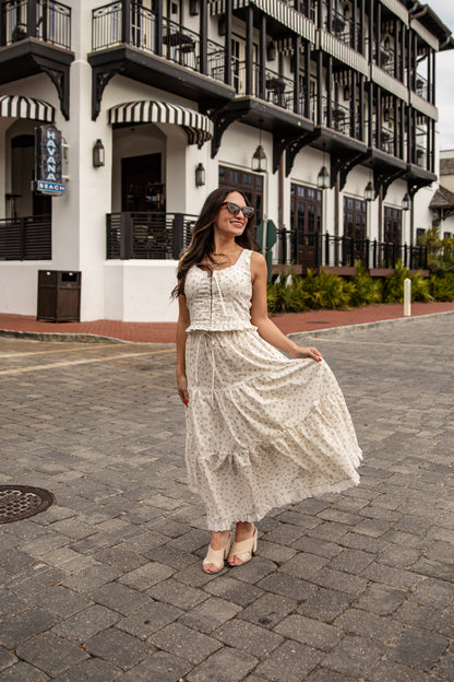 Woman in a white lace dress standing on a street with a building in the background