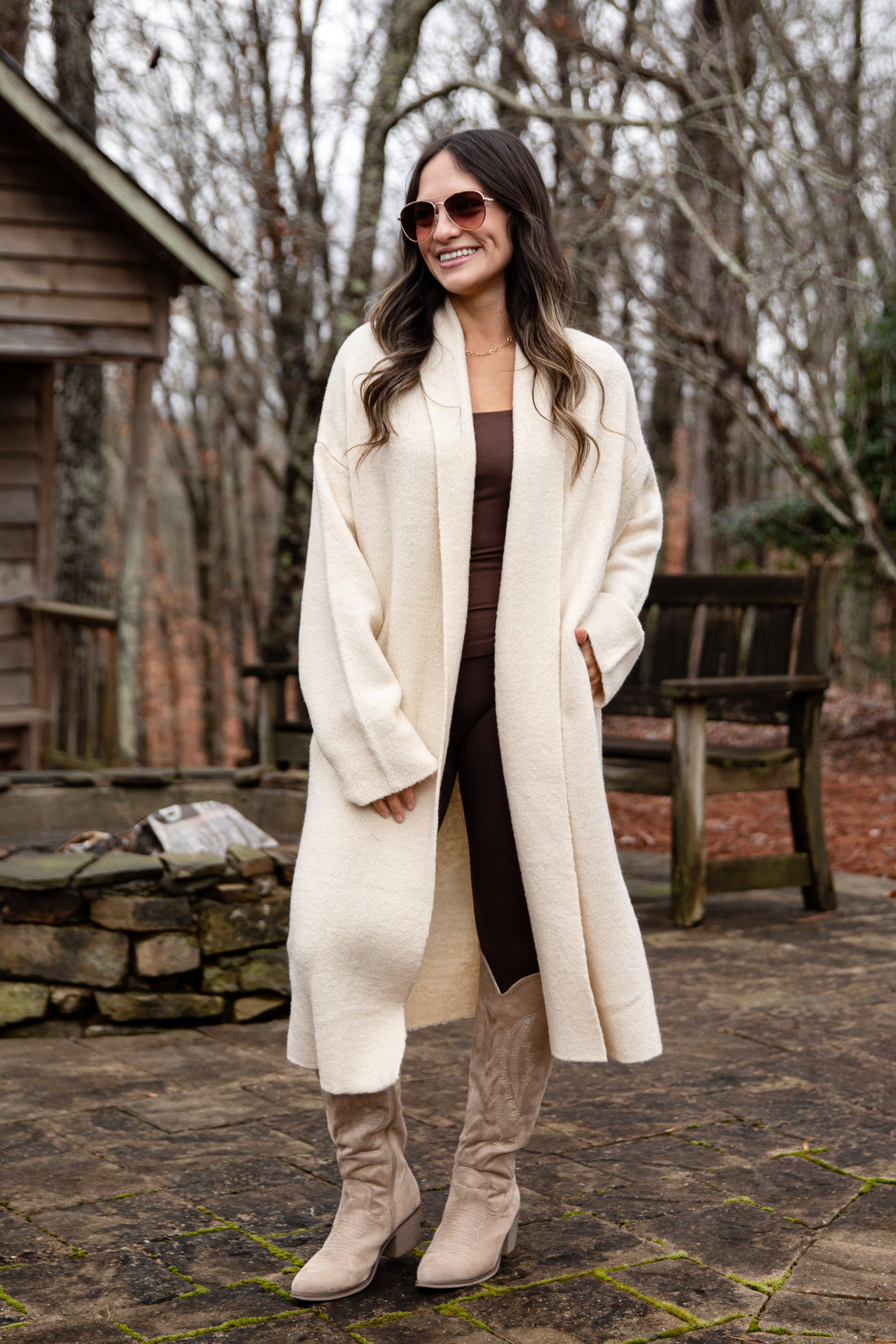 Woman wearing a long white coat in a forest setting