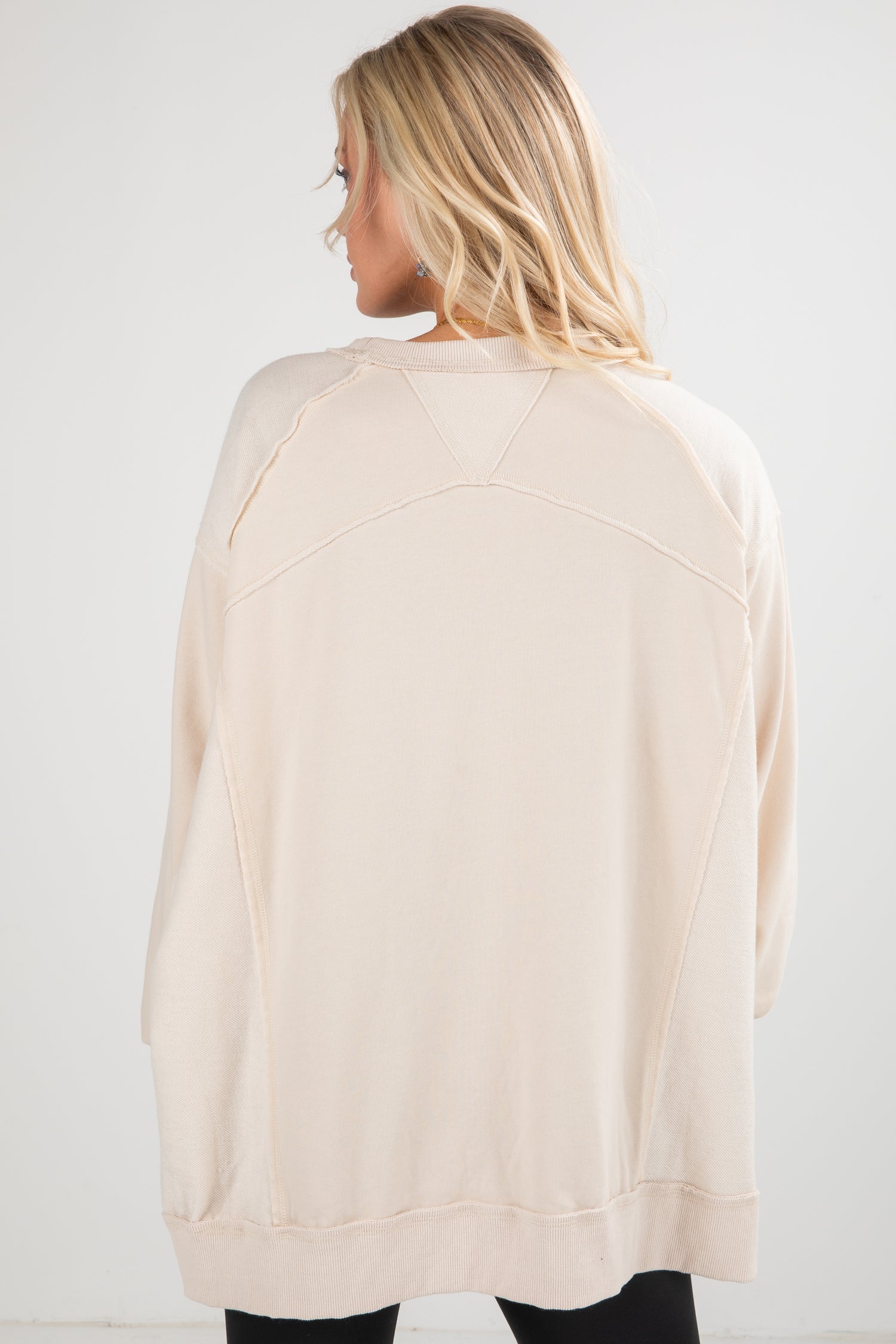 Woman wearing a beige cardigan against a white background