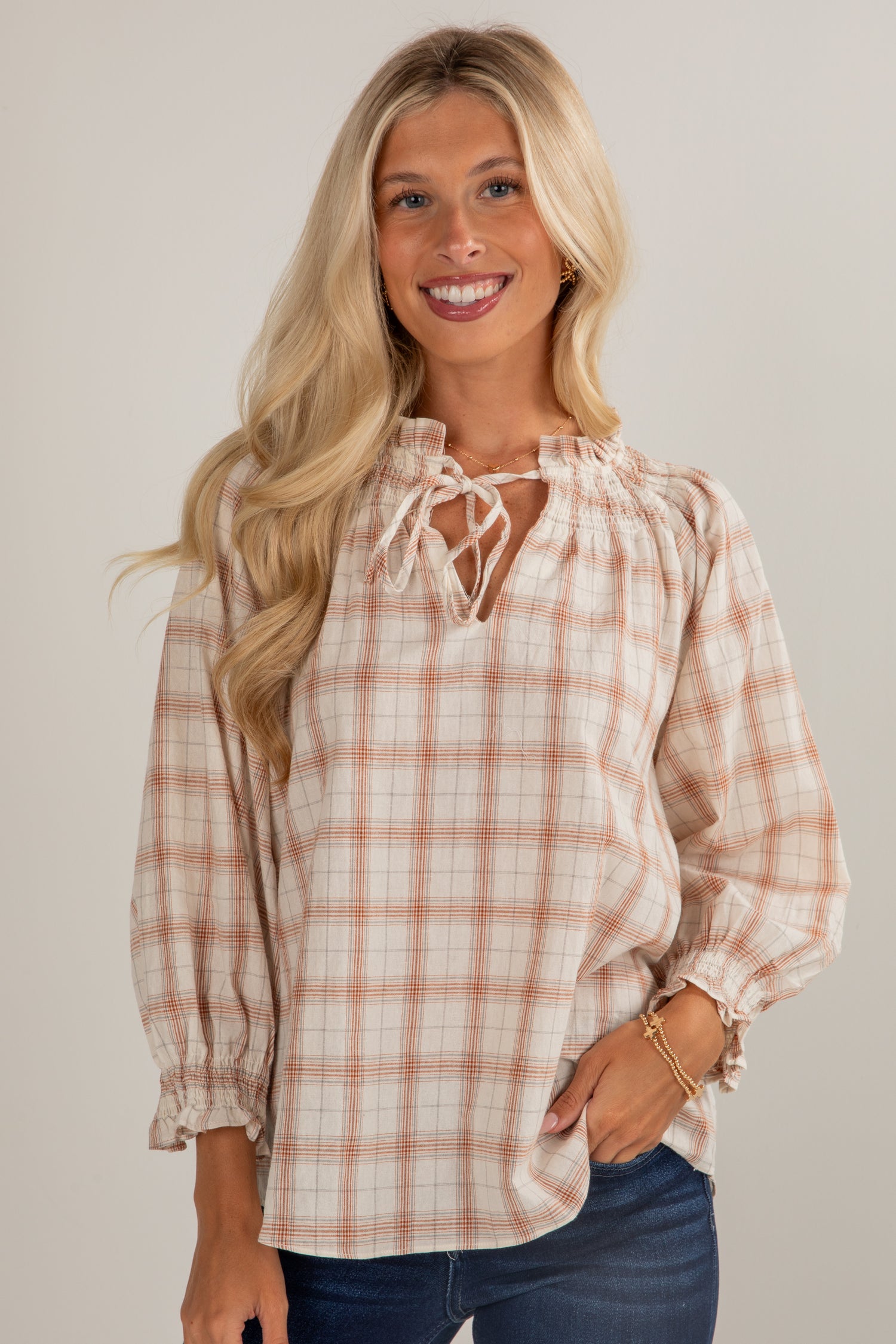 Woman wearing a plaid blouse with a neutral background
