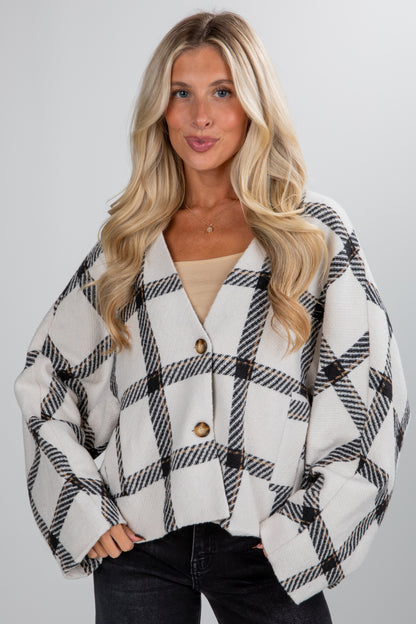 Woman wearing a black and white checkered jacket on a gray background
