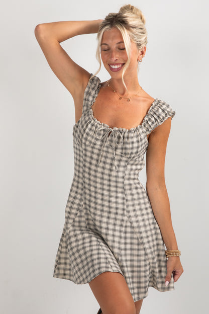Woman wearing a checkered dress against a plain background