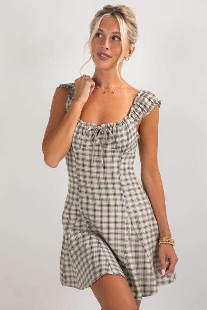 Woman wearing a checkered dress on a plain background
