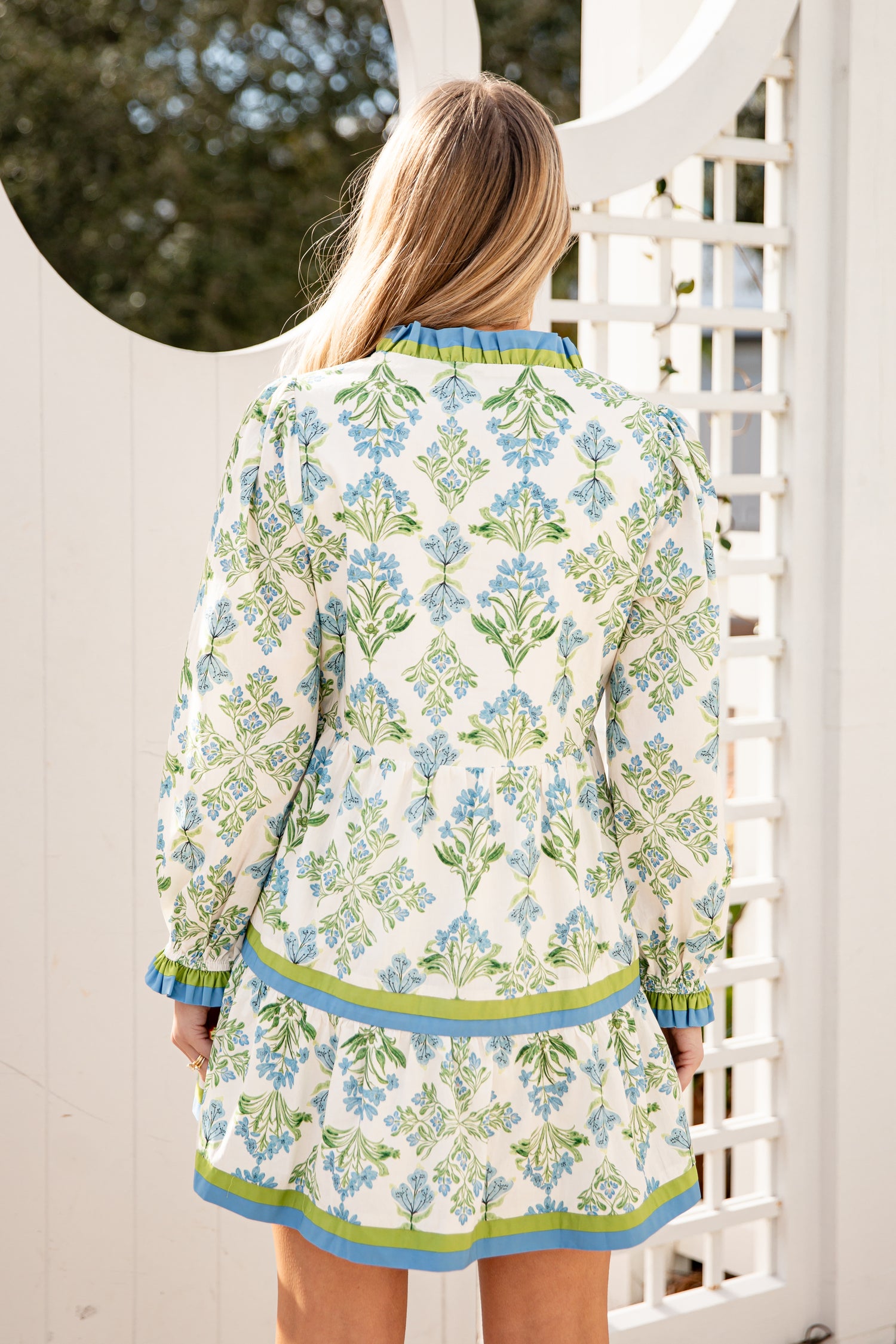 Woman wearing a floral dress with a white lattice background