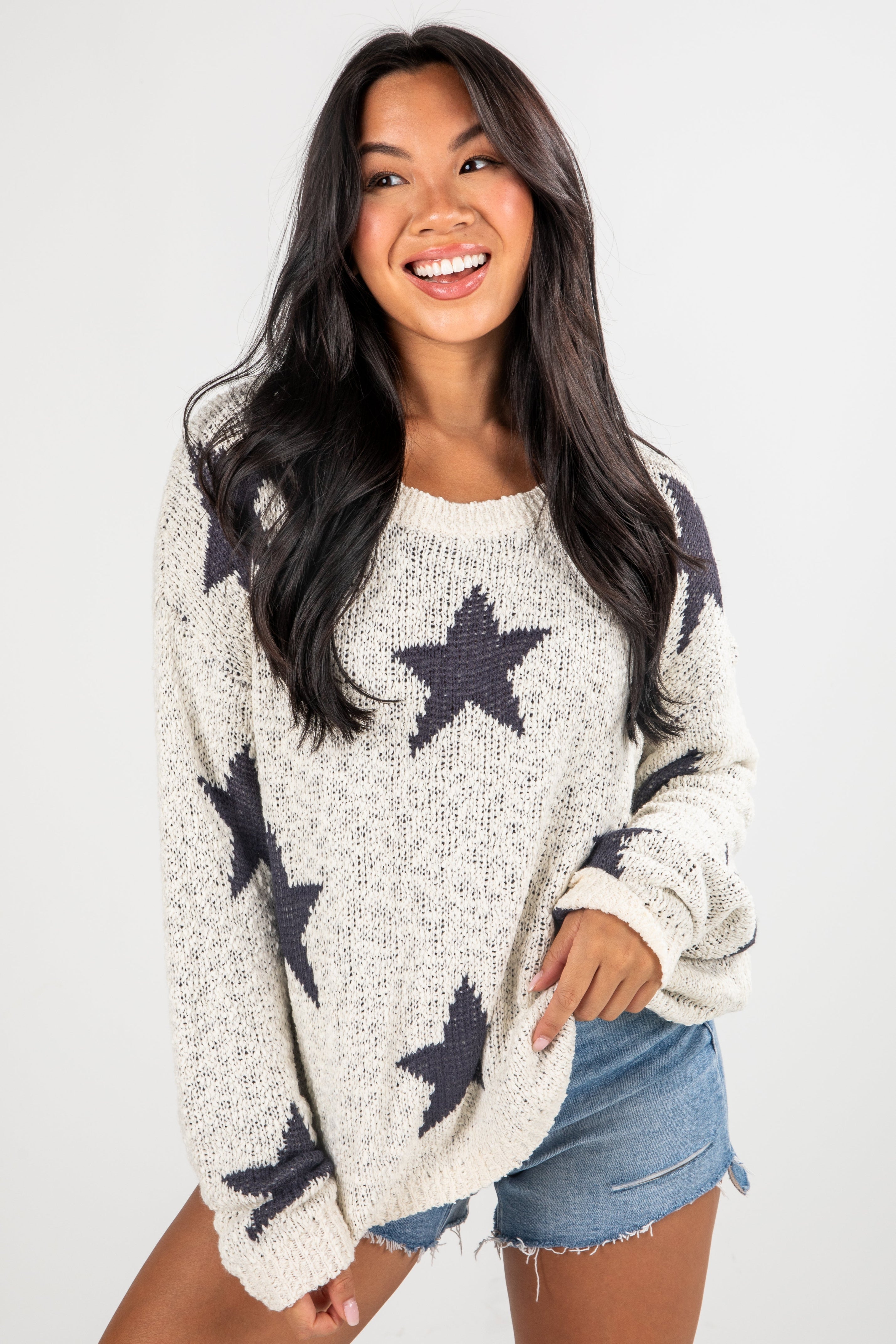 Woman wearing a sweater with star patterns on a plain background