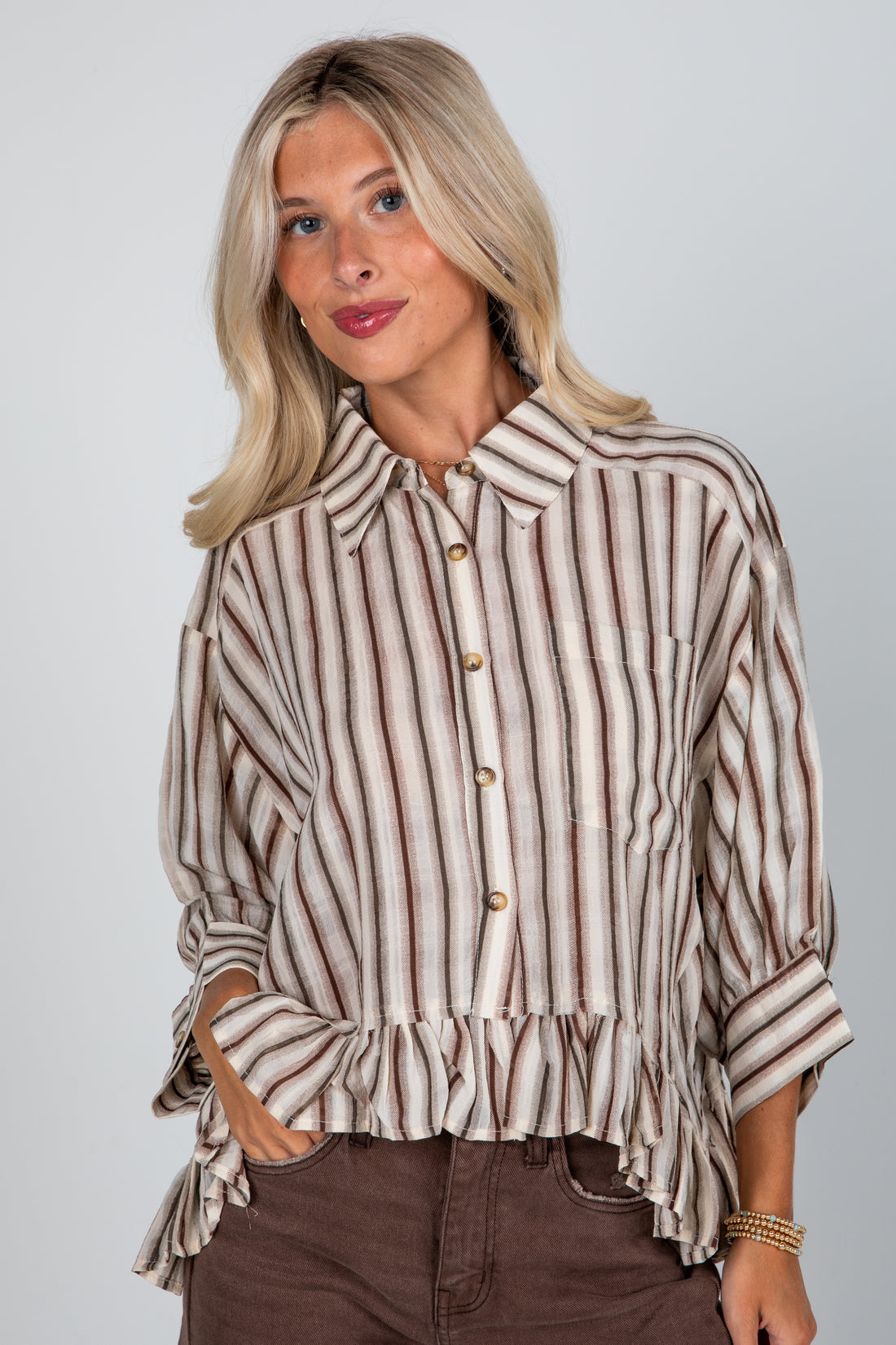 Woman wearing a striped shirt with a plain background