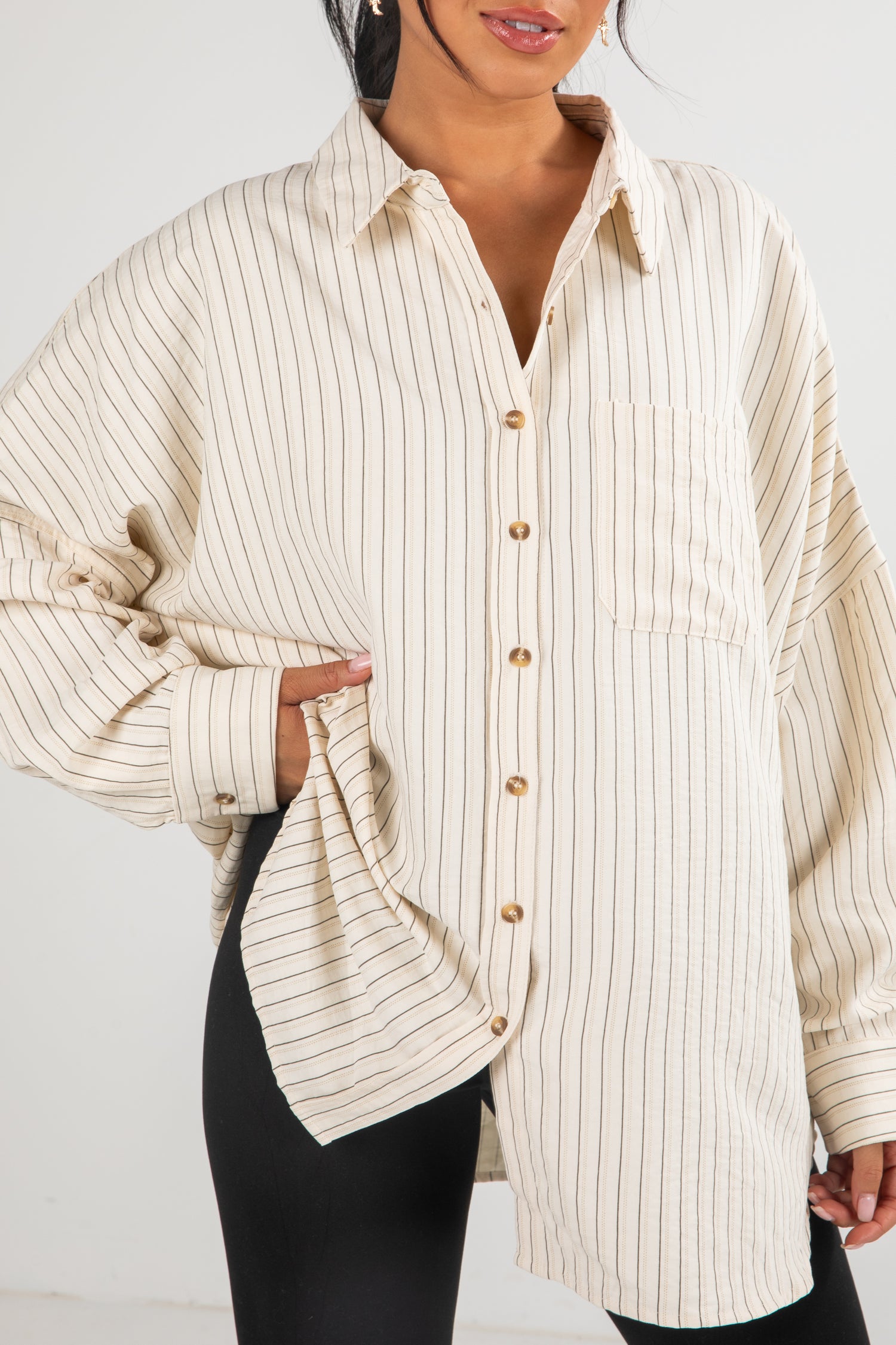Person wearing a beige striped shirt with a white background