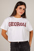 A woman wearing a white cropped t-shirt with &