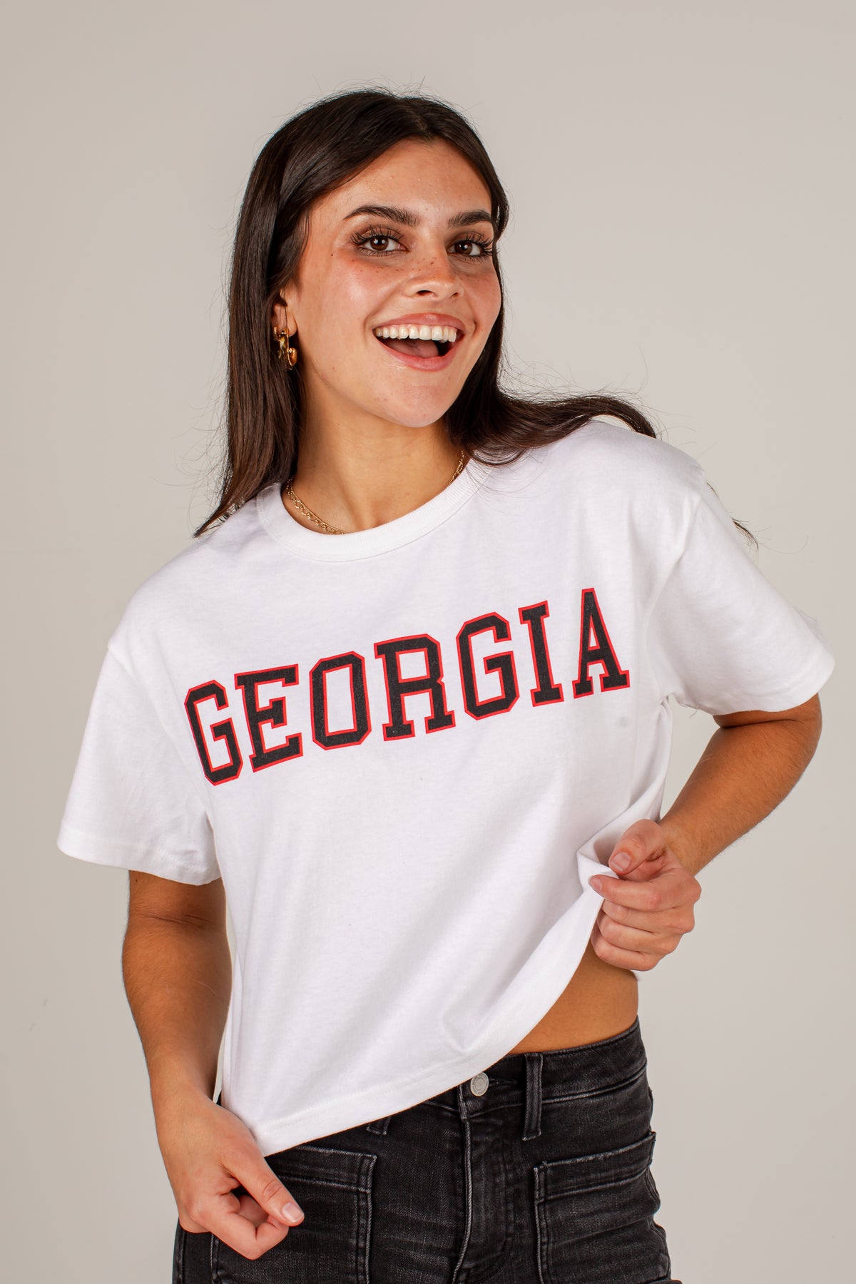 A woman wearing a white cropped t-shirt with &