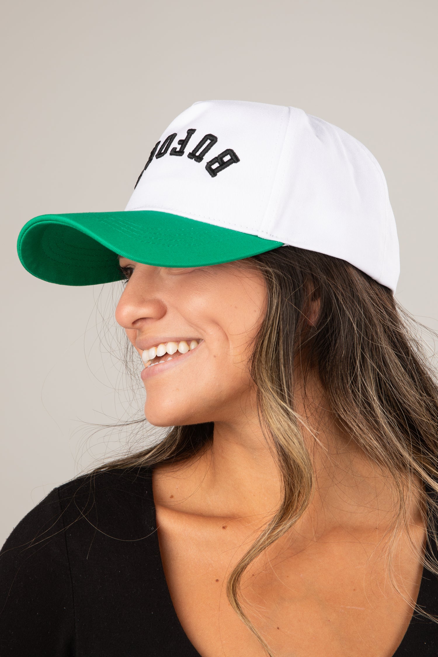 Woman wearing a white and green cap with &