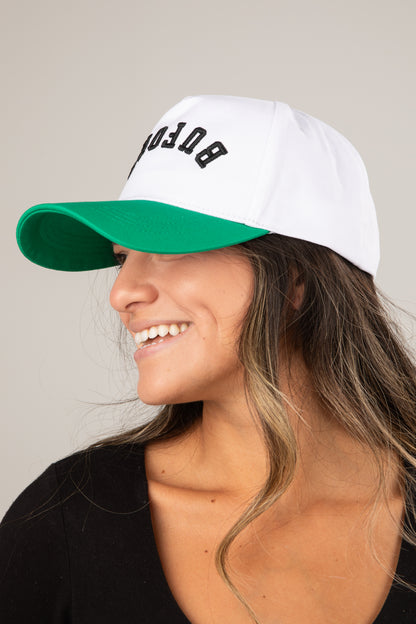 Woman wearing a white and green cap with &