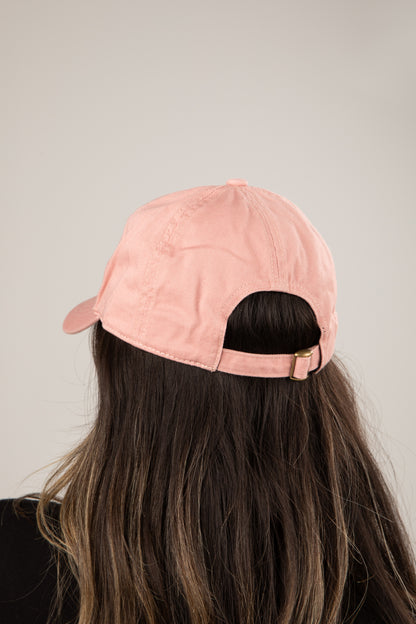 Person wearing a pink cap on a plain background