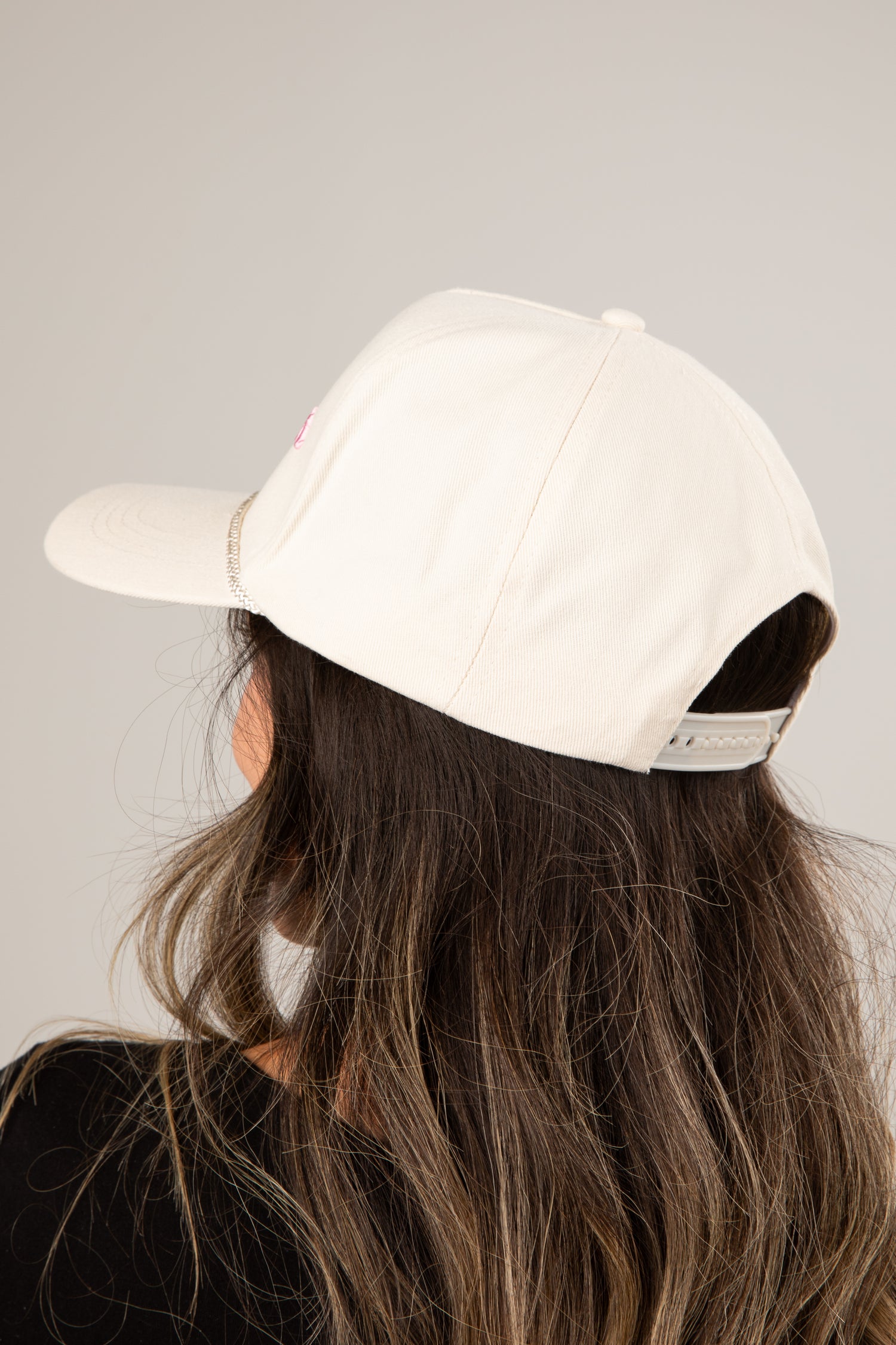 Person wearing a beige cap on a plain background