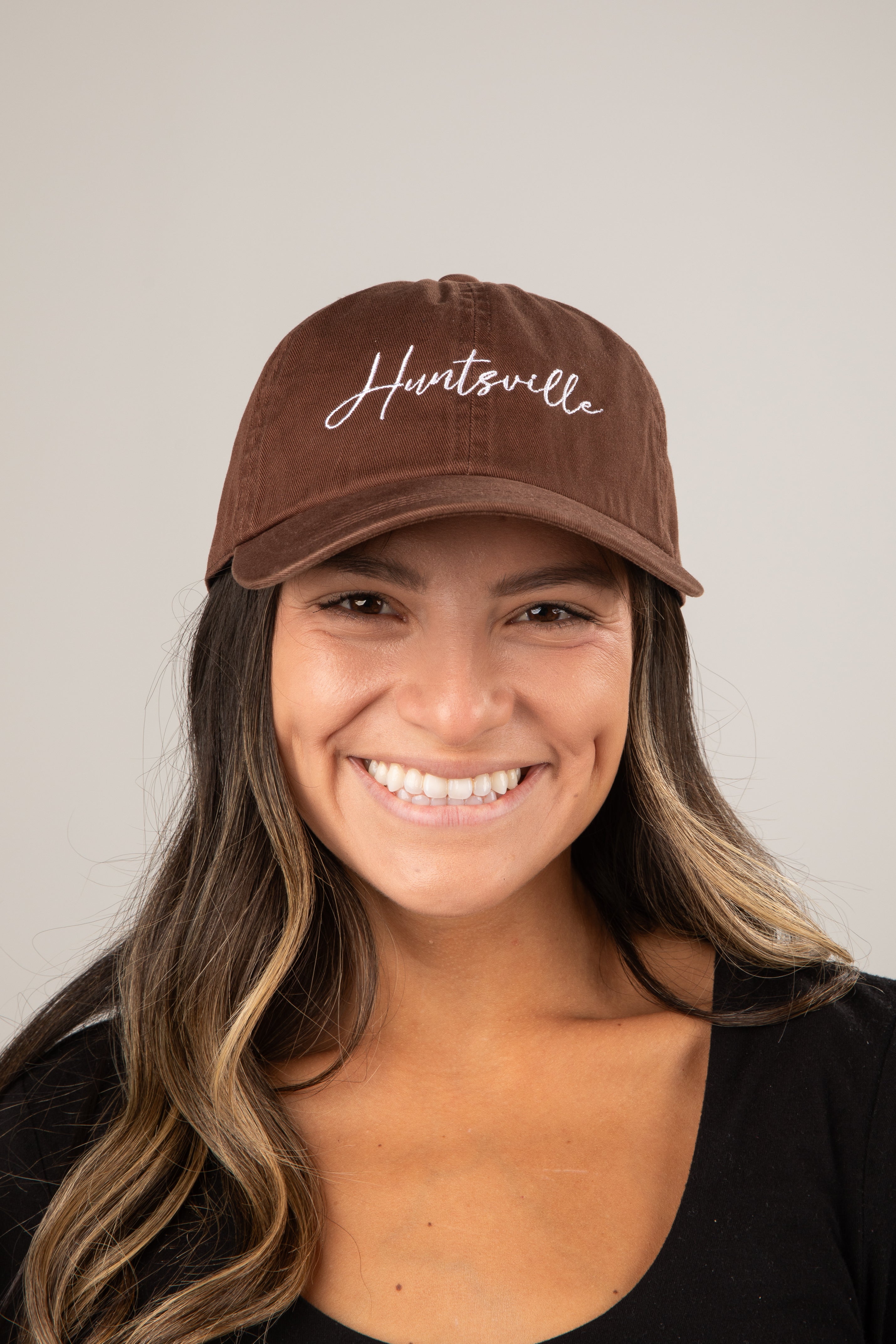 Woman wearing a brown cap with &