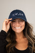 Woman wearing a navy blue cap with &