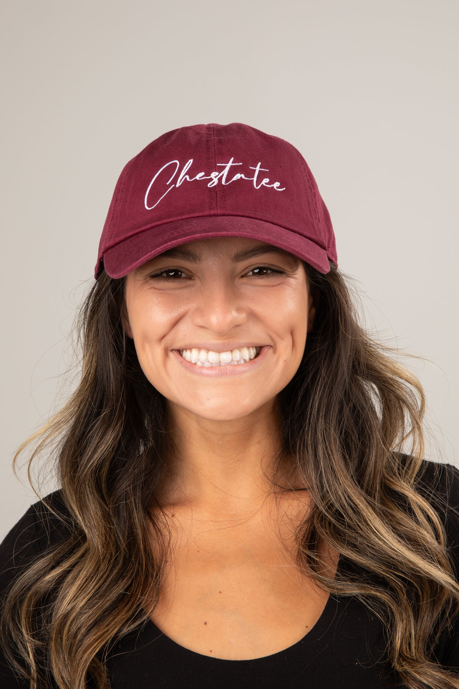 Woman wearing a maroon cap with &