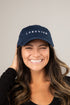 Woman wearing a navy blue cap with &