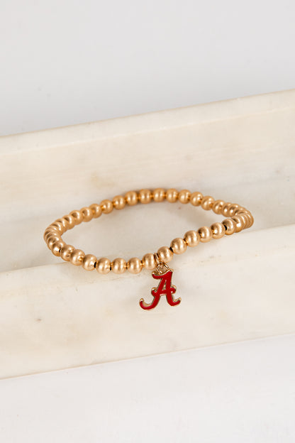 Gold beaded bracelet with a red &