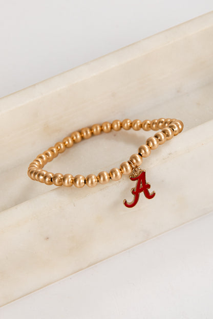 Gold beaded bracelet with a red &