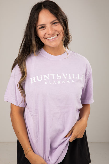 Woman wearing a lavender t-shirt with &