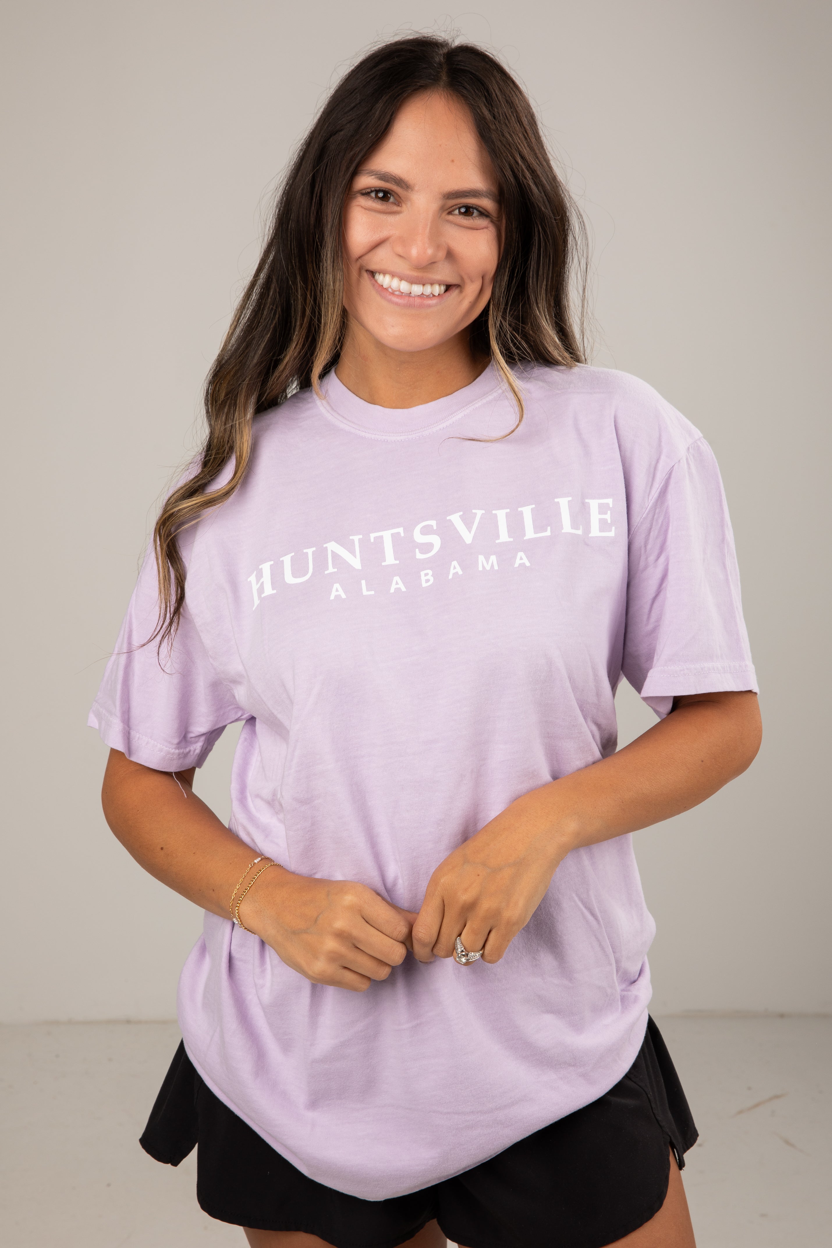Woman wearing a lavender t-shirt with &
