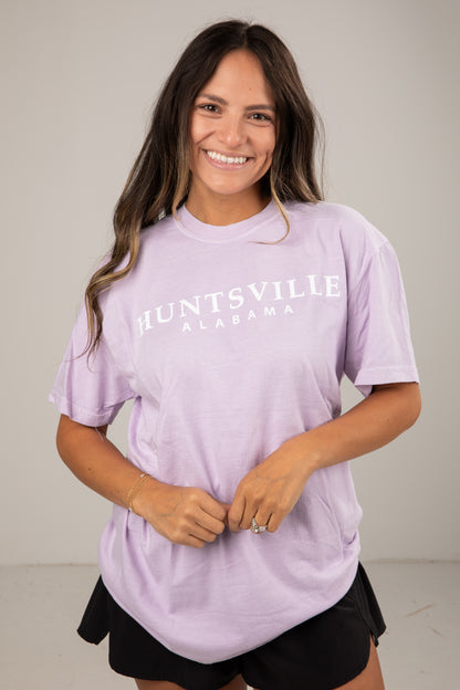 Woman wearing a lavender t-shirt with &