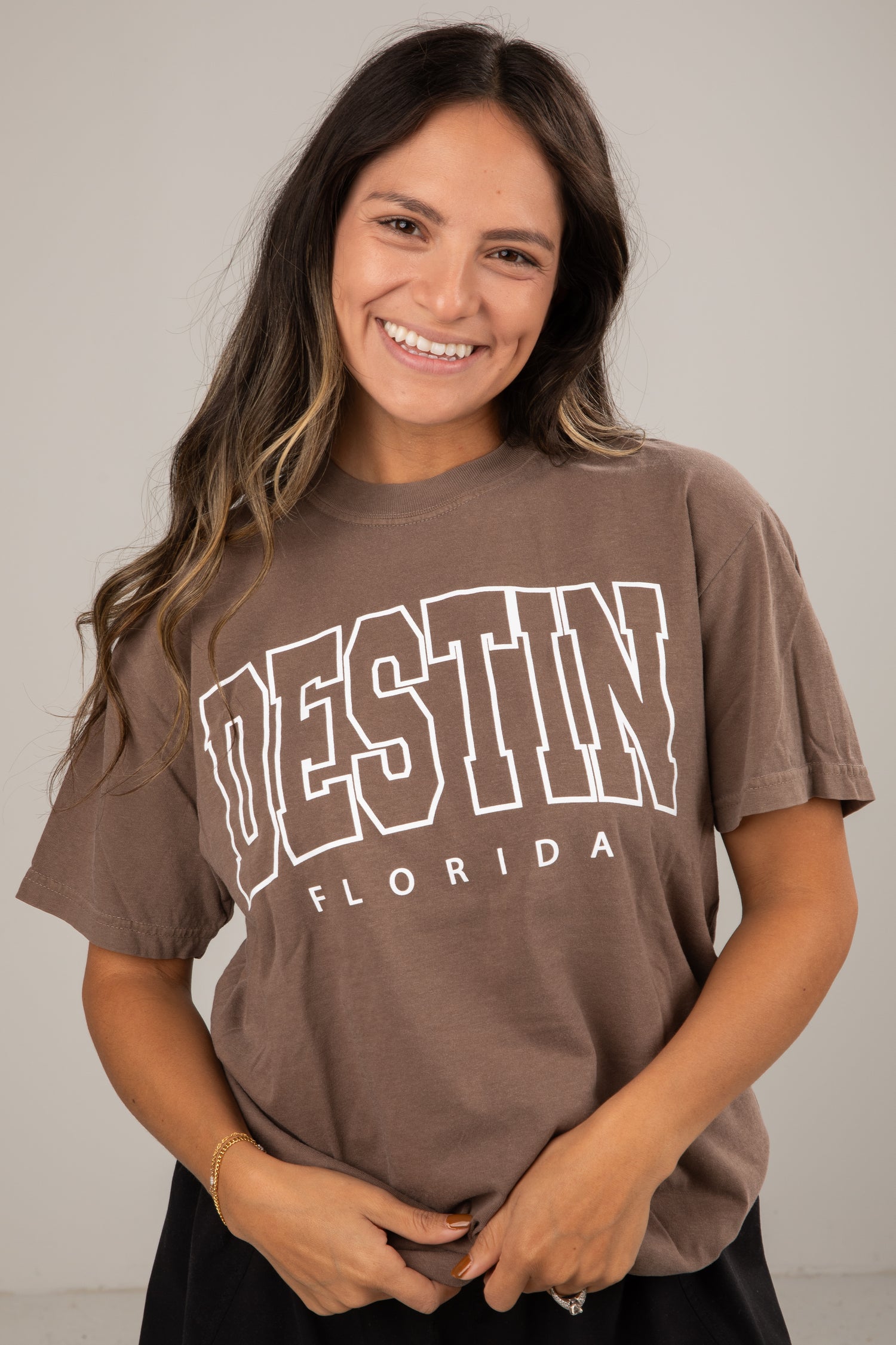 Woman wearing a brown t-shirt with &
