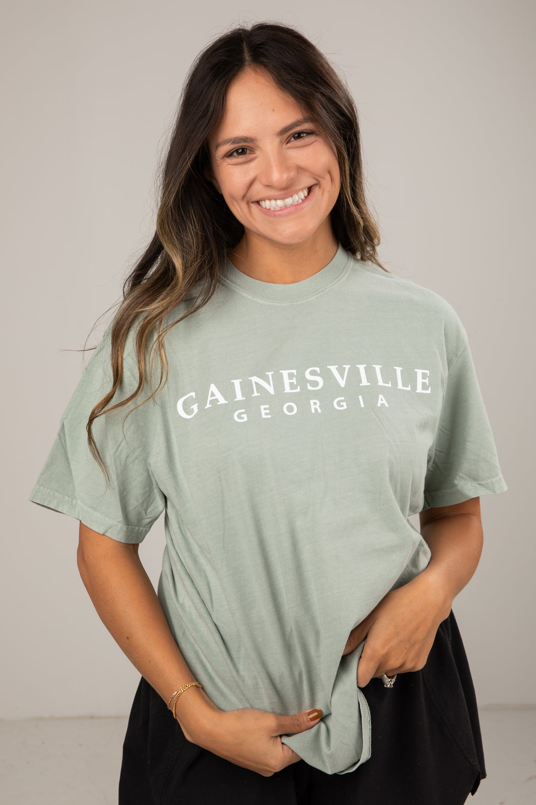 Woman wearing a light green t-shirt with &