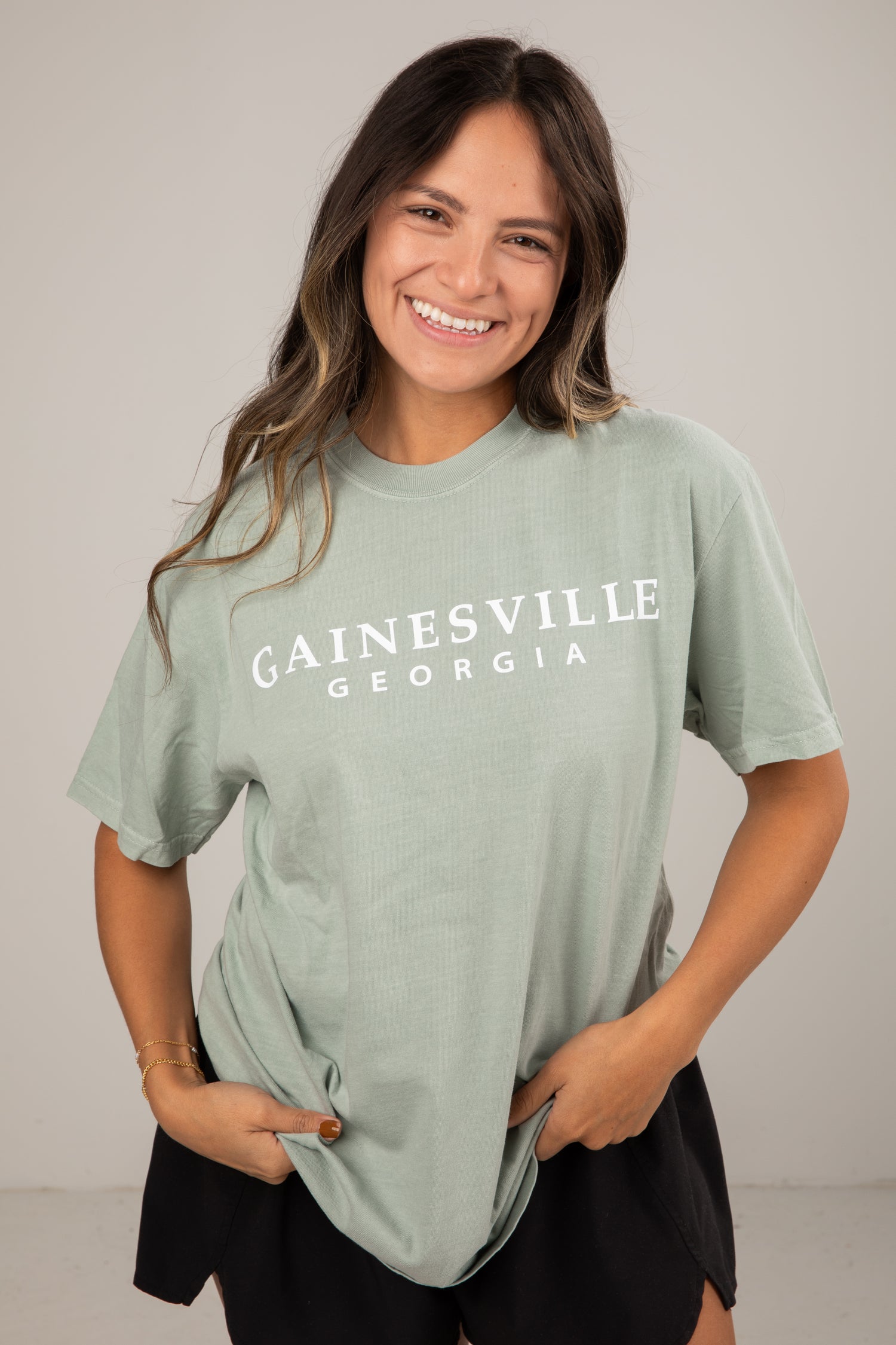 Woman wearing a green t-shirt with &