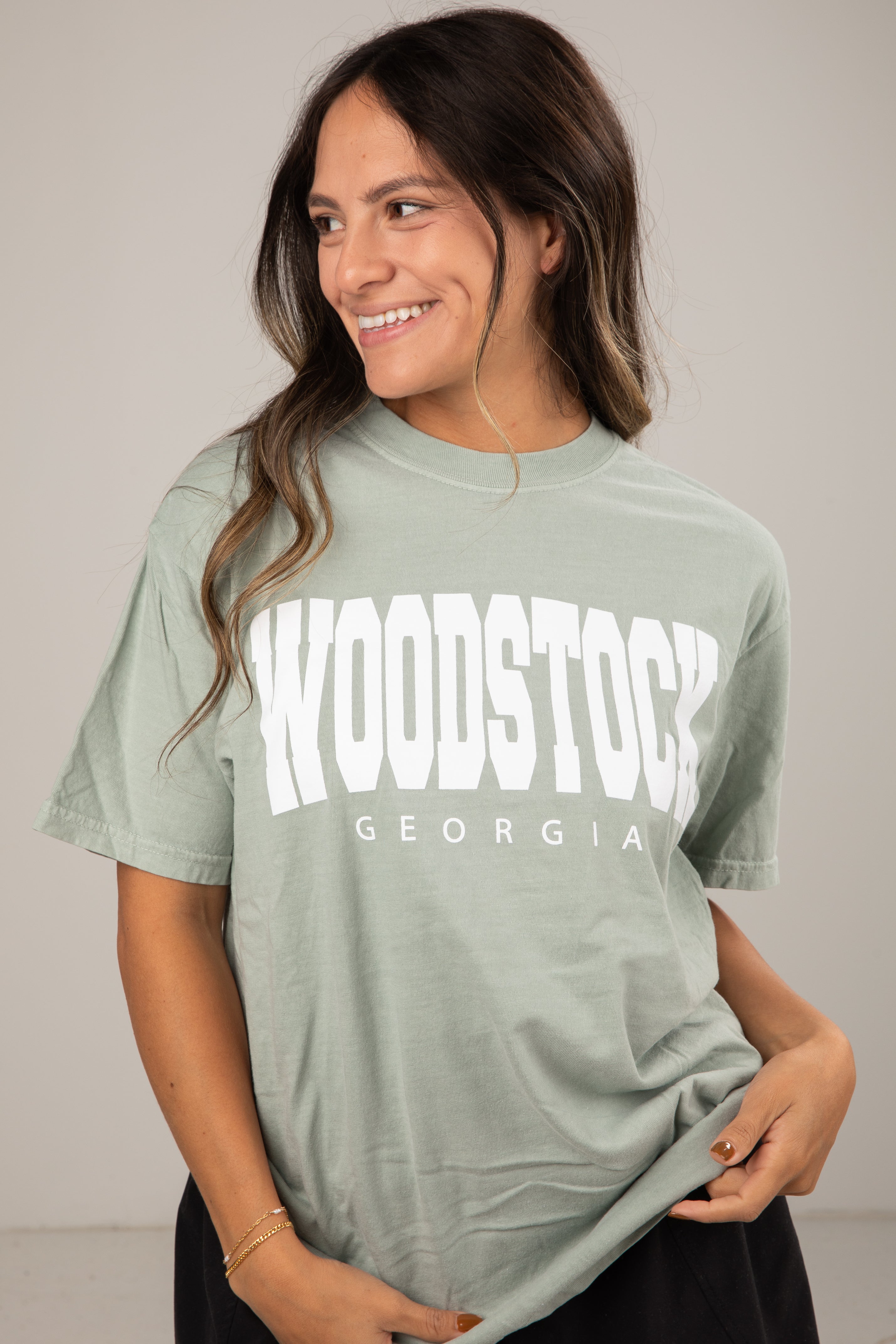Woman wearing a green t-shirt with &