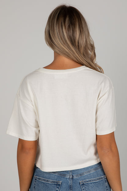 Person wearing a white t-shirt and blue jeans against a gray background