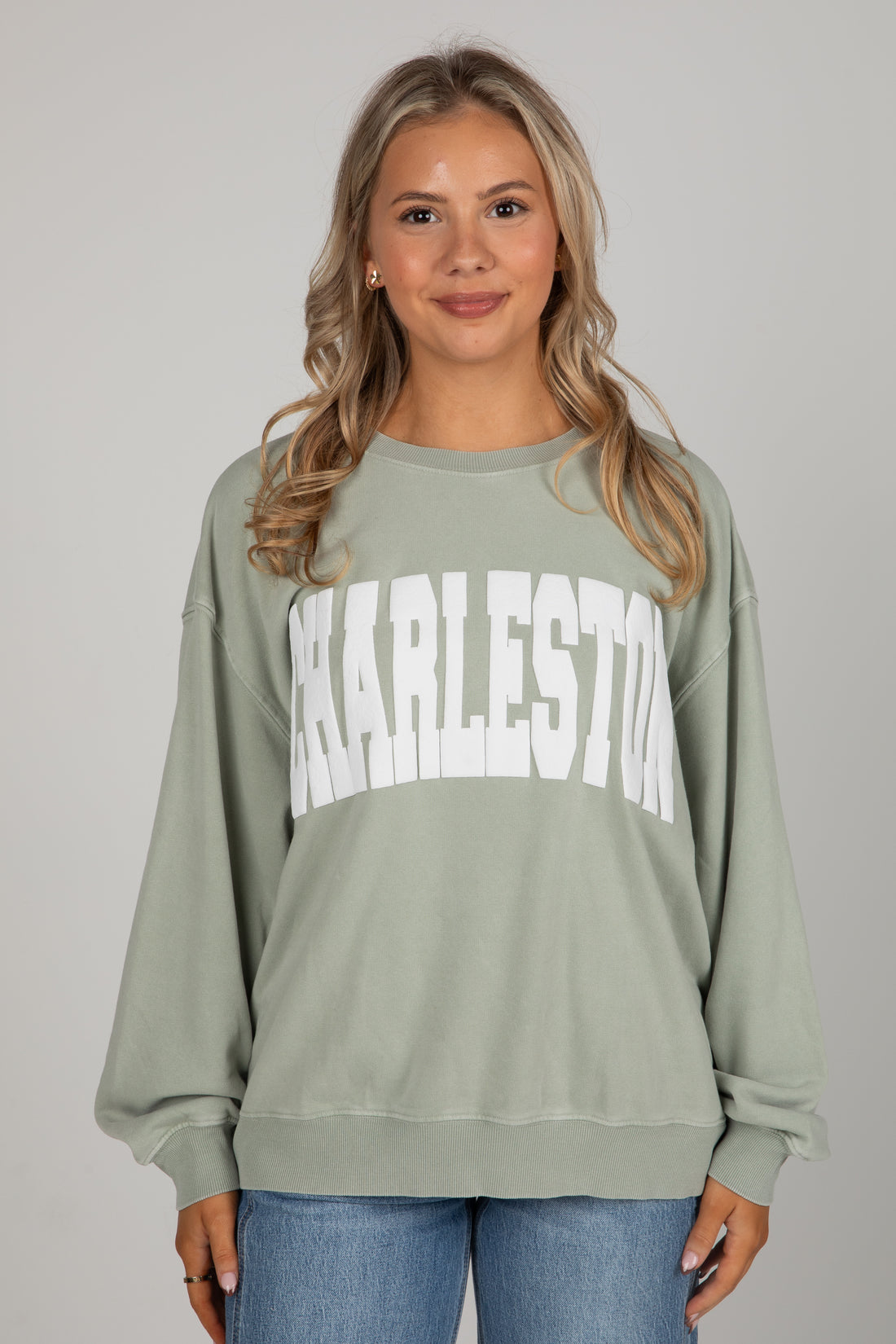 Woman wearing a green sweatshirt with &