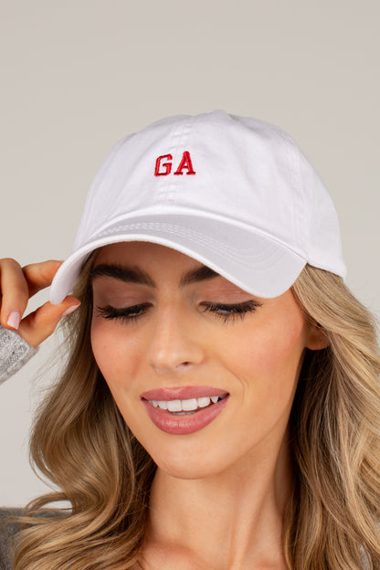 A woman wearing a white baseball cap with red embroidered letters &